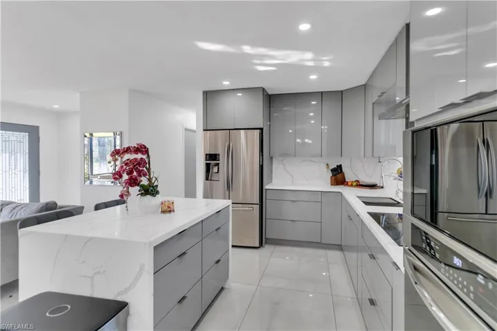 Kitchen with stainless steel appliances, modern cabinets, a sink, and gray cabinetry