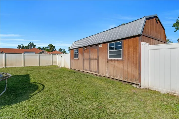 View of yard with an outdoor structure and a fenced backyard