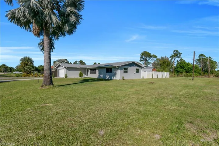 View of front facade featuring a front lawn and fence