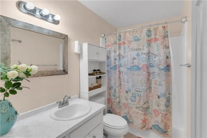 Bathroom featuring vanity, shower / bath combo with shower curtain, and toilet