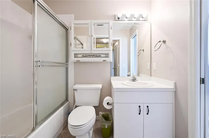 Full bathroom with vanity and enclosed tub / shower combo