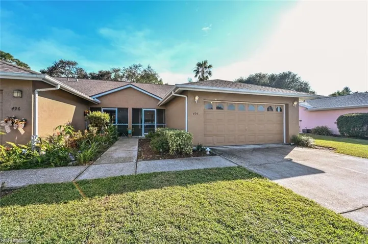 Ranch-style house with stucco siding, driveway, a front lawn, and an attached garage