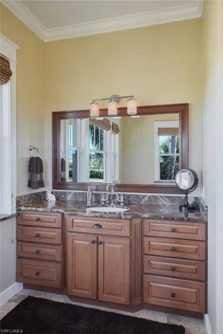 "her" vanity and sink showcasing the beautiful cabinetry.