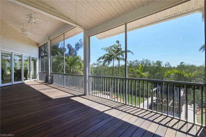 Another view of the screened balcony overlooking the firepit and boat dock