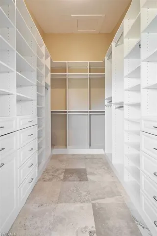 Primary bedroom with walk in closet with custom shelving