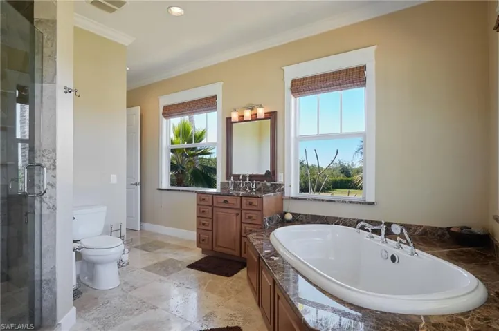 Primary bathroom with "his" sink, jetted tub, separate shower to the right.