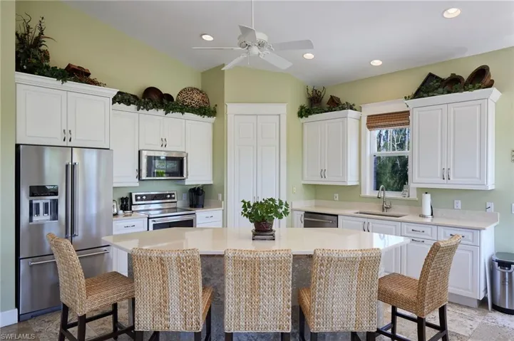 Kitchen featuring a large kitchen island enough to seat five, quartz countertops, and 3-year-old KitchenAid stainless steel appliances.