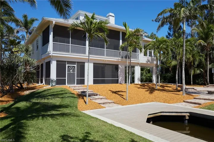 View of the back of the house showing the screened areas at ground level and above balcony