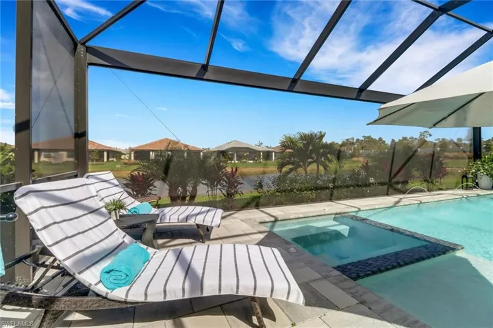 View of swimming pool with a water view and a patio