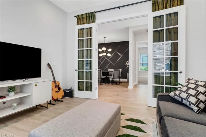 Living room with french doors, an inviting chandelier, and hardwood / wood-style flooring