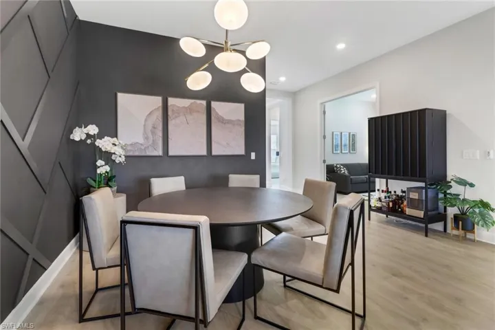 Dining space with light hardwood / wood-style flooring and an inviting chandelier
