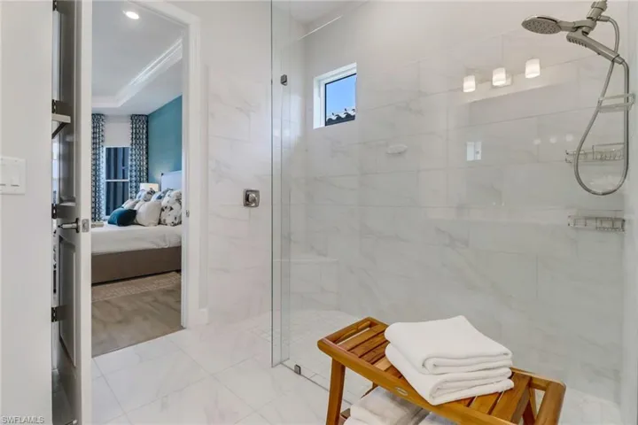 Bathroom featuring a tile shower, hardwood / wood-style flooring, and a raised ceiling