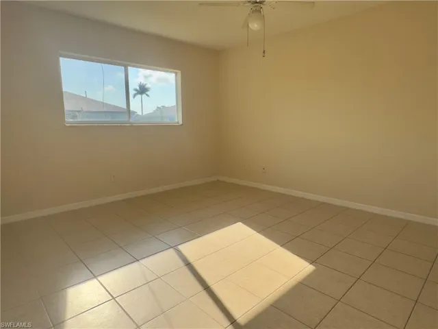 Tiled primary room with ceiling fan