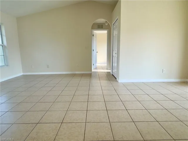 Tiled empty room with high vaulted ceiling