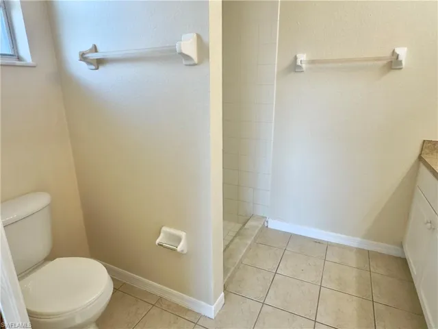 Bathroom featuring tile flooring, vanity, and toilet