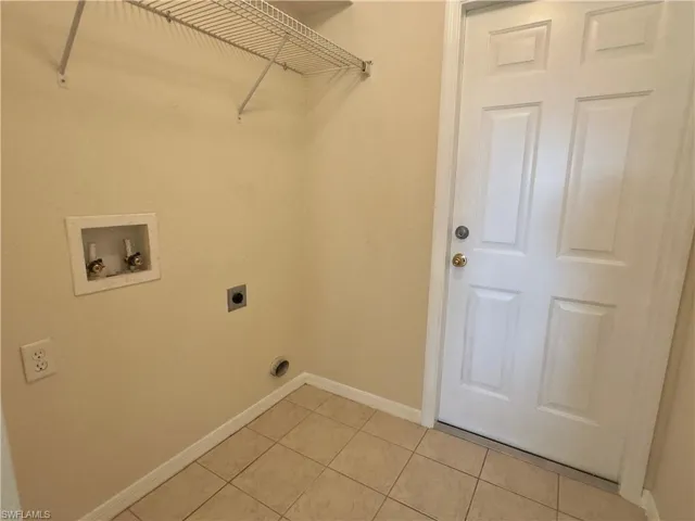 Clothes washing area featuring electric dryer hookup, washer hookup, and tile floors