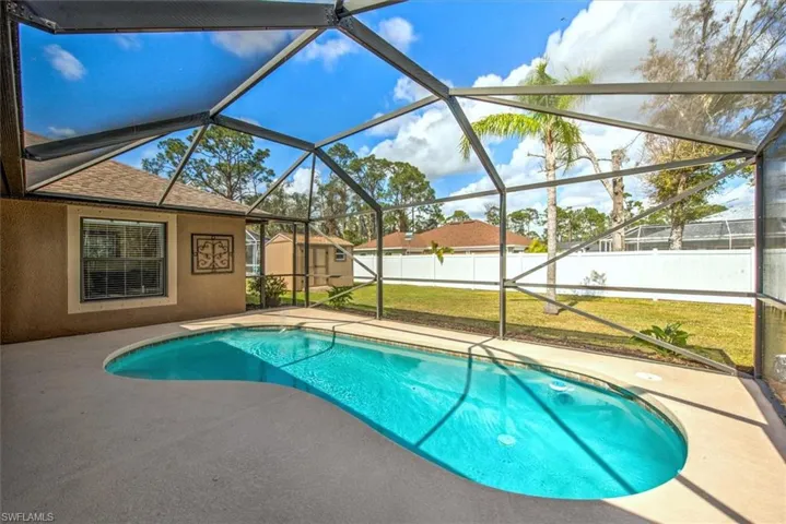 View of swimming pool with a lanai, a lawn, and a patio area