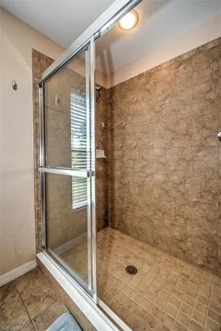 Bathroom featuring walk in shower and a textured ceiling