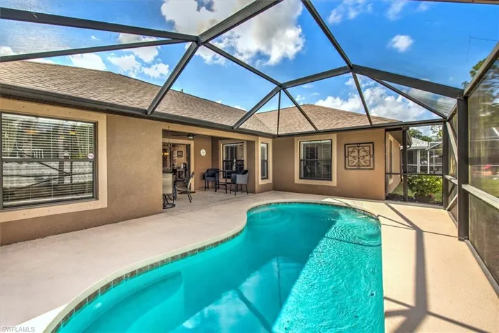 View of swimming pool featuring a lanai and a patio area