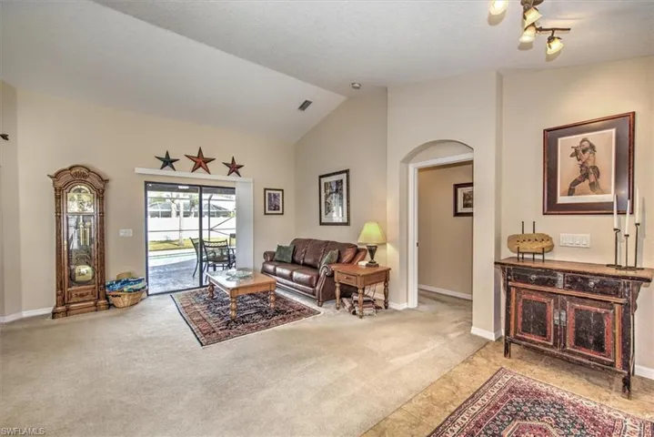 Carpeted living room with vaulted ceiling and a textured ceiling
