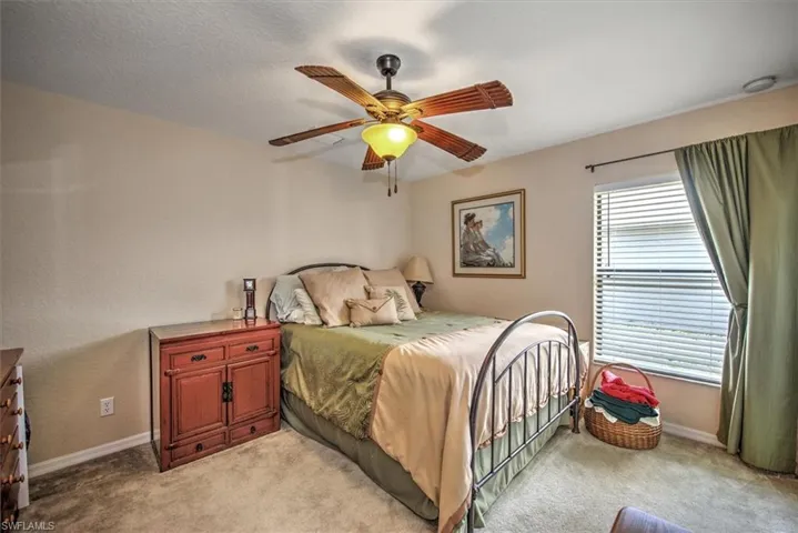 Carpeted bedroom featuring a textured ceiling and ceiling fan
