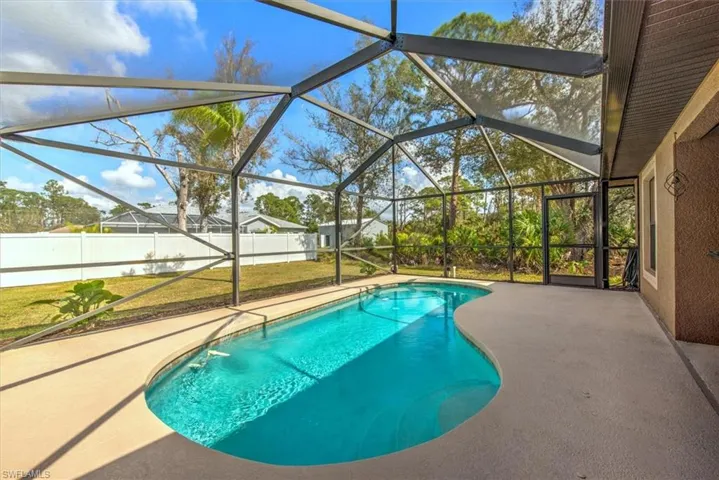 View of swimming pool featuring a patio and glass enclosure