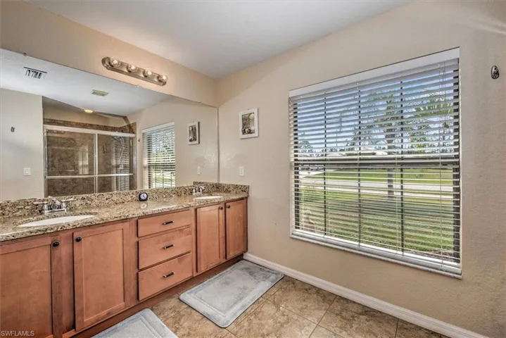 Bathroom featuring vanity, tile patterned flooring, and walk in shower