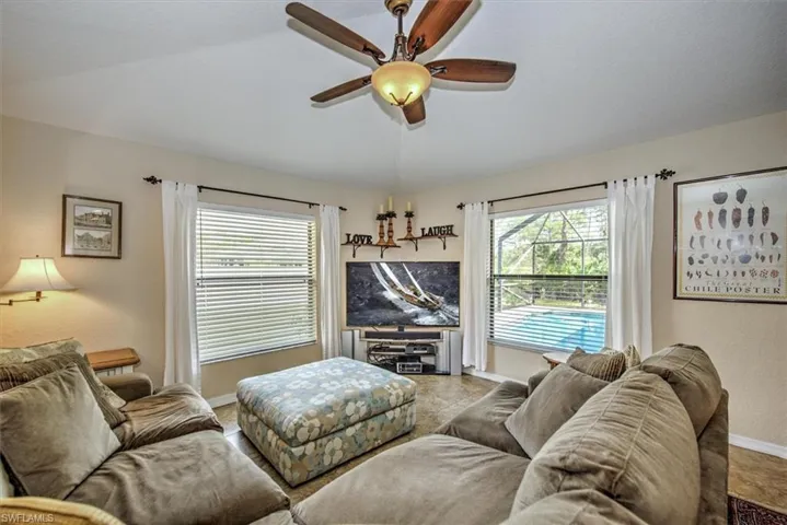 Living room featuring ceiling fan and vaulted ceiling