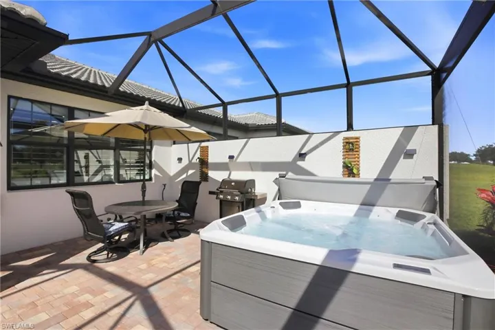 Lanai with hot tub and additional table/seating.