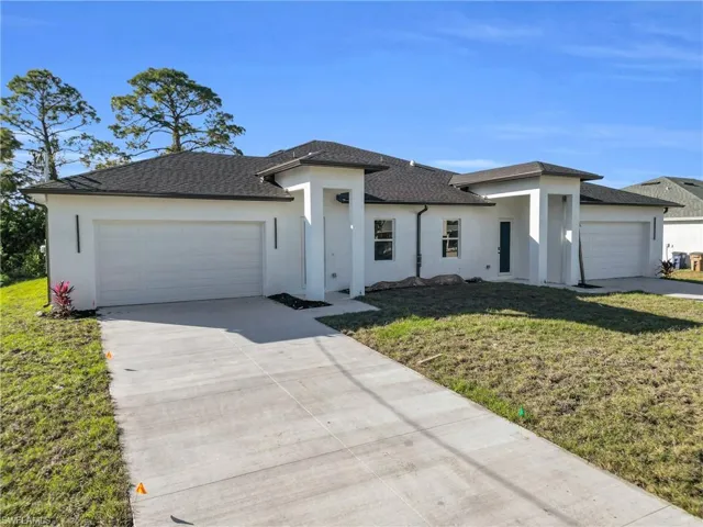 Prairie-style home featuring a front yard, a garage, and stucco siding
