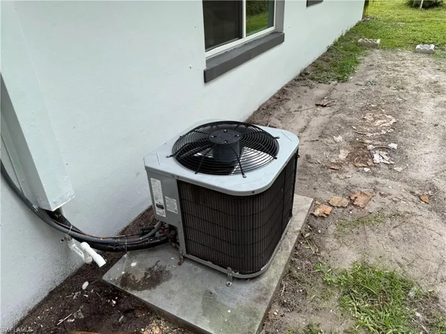 Exterior view of stucco siding and a cooling unit