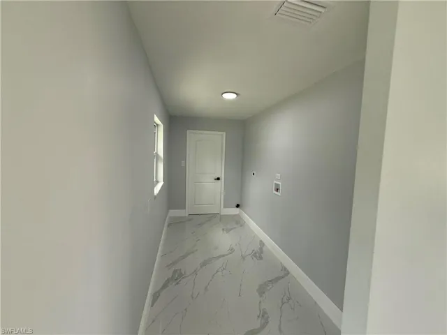 Hall featuring baseboards and light marble finish flooring