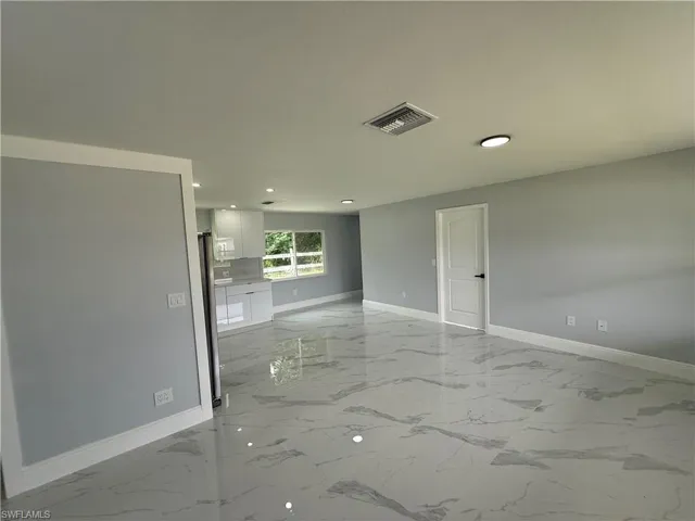 Unfurnished room featuring light marble finish floors and recessed lighting