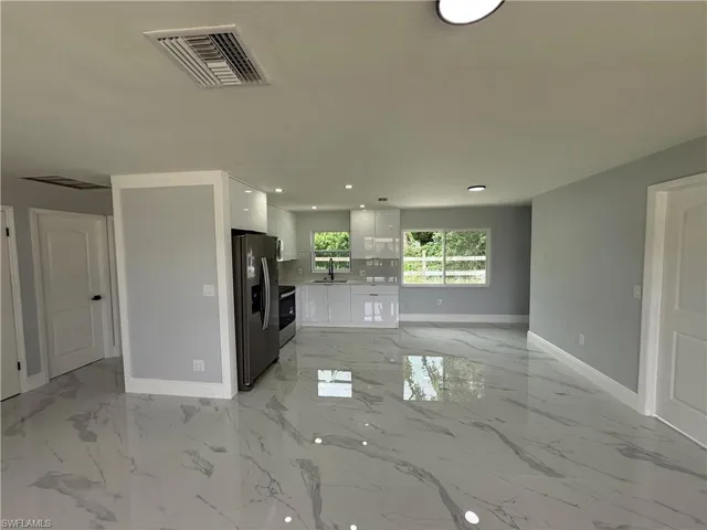 Unfurnished living room with light marble finish flooring and recessed lighting