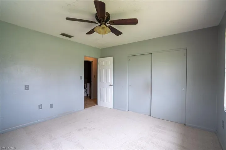 Unfurnished bedroom with a closet, carpet floors, and ceiling fan
