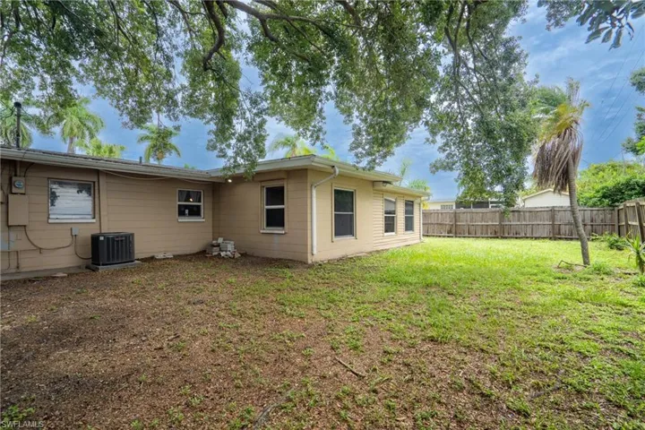 Back of house featuring a yard and central AC