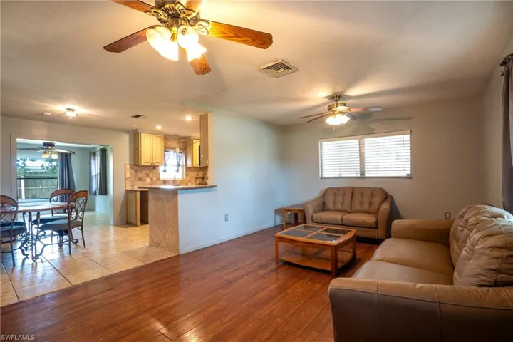 Living room with ceiling fan and light hardwood / wood-style floors