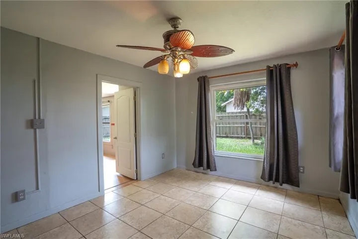 Tiled spare room featuring ceiling fan