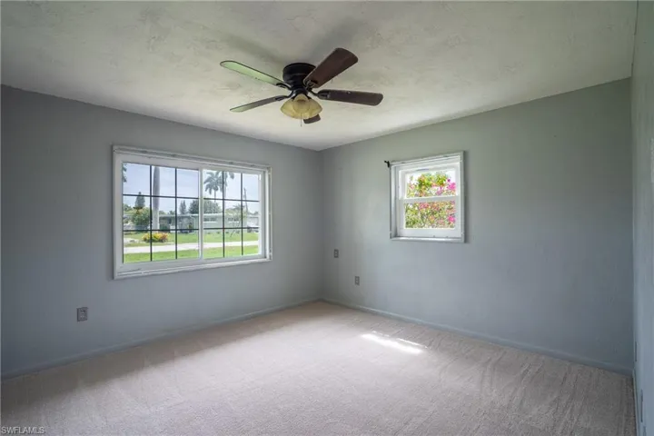 Unfurnished room with plenty of natural light, ceiling fan, and carpet floors