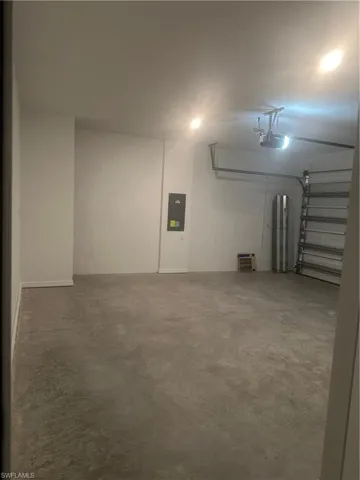 Garage with a concrete floor, recessed lighting, and an automatic garage door opener
