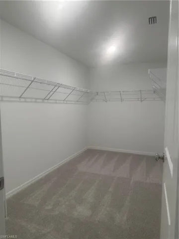 Light-colored walls, light-colored carpeting, and wire shelving system