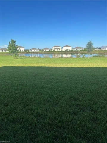 Expansive green lawn with a water feature backdrop