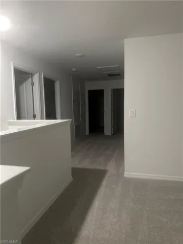 Hallway with carpet flooring and light gray walls