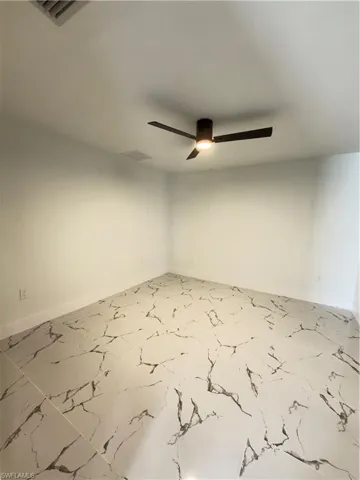 Empty room featuring baseboards and ceiling fan