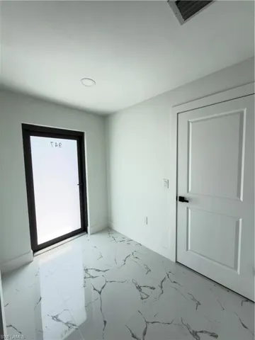 Spare room with light marble finish floors