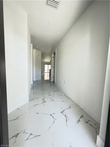 Unfurnished room featuring baseboards and light marble finish flooring