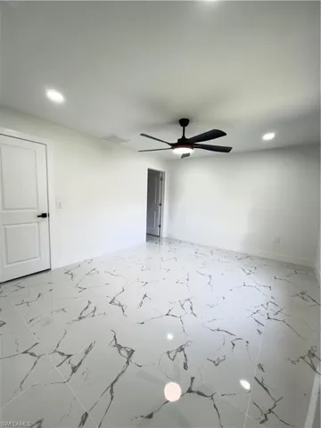 Empty room featuring recessed lighting, ceiling fan, and light marble finish flooring