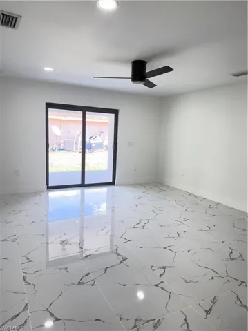 Empty room featuring light marble finish floors, recessed lighting, and a ceiling fan