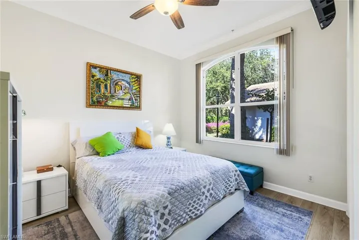 Guest bedroom featuring wood finished tile floors and ceiling fan.