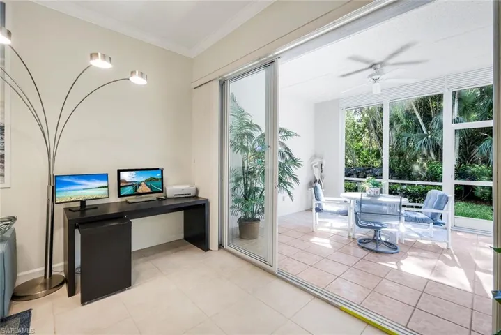 Home office work area light tile patterned floors, crown molding and rear sliders leading into the rear Lanai.